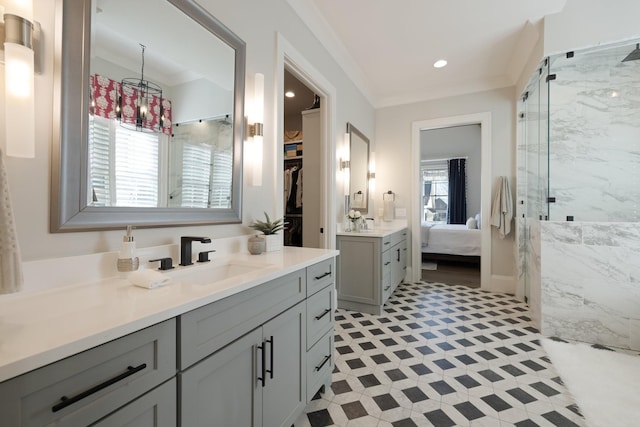 bathroom featuring vanity, a shower with shower door, and ornamental molding