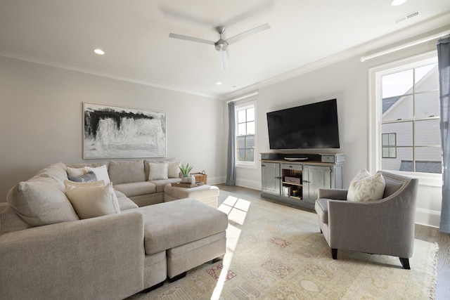 living room featuring ornamental molding, ceiling fan, and light wood-type flooring