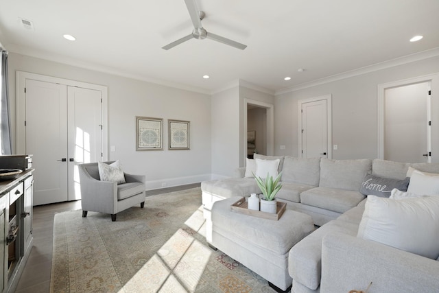 living room featuring ornamental molding, wood-type flooring, and ceiling fan