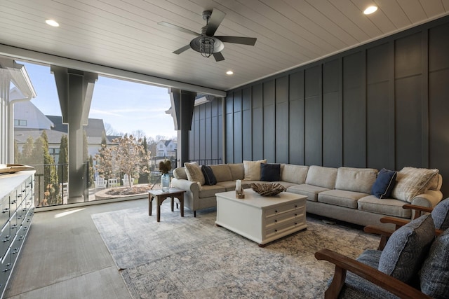 living room featuring ceiling fan, a wall of windows, and wooden ceiling