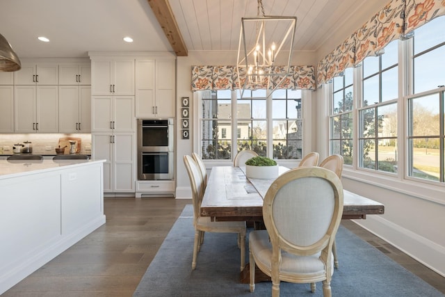 dining area with beam ceiling, dark wood-type flooring, and a chandelier