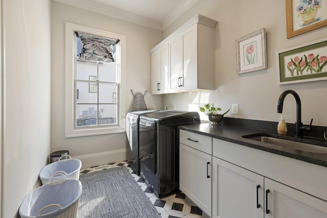 laundry area with cabinets, crown molding, sink, and washing machine and clothes dryer