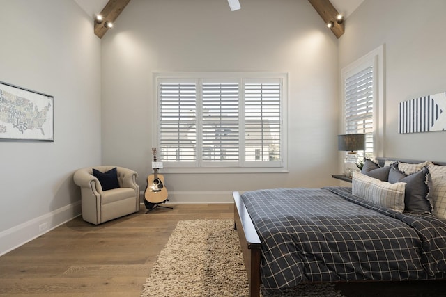 bedroom featuring high vaulted ceiling, hardwood / wood-style floors, and beam ceiling