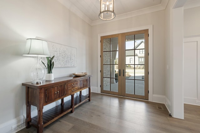 doorway to outside featuring hardwood / wood-style floors, ornamental molding, french doors, and a chandelier