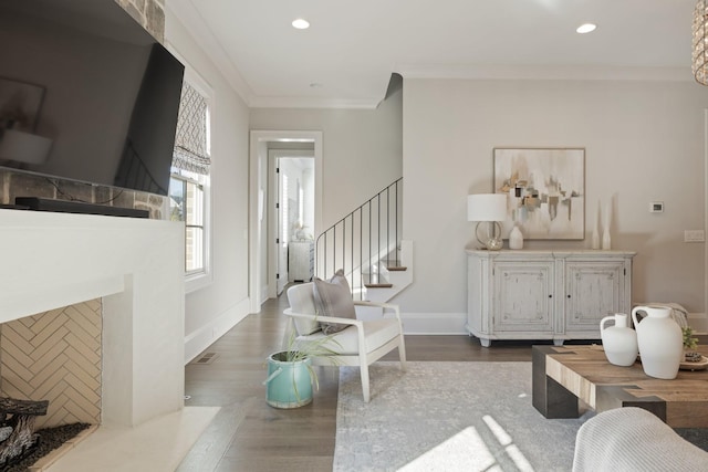 living room with a premium fireplace, ornamental molding, and dark hardwood / wood-style floors