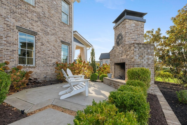 view of patio / terrace featuring an outdoor brick fireplace