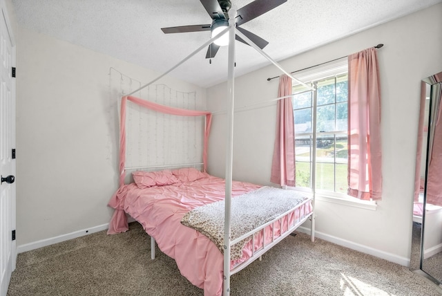 bedroom with multiple windows, carpet, a textured ceiling, and ceiling fan