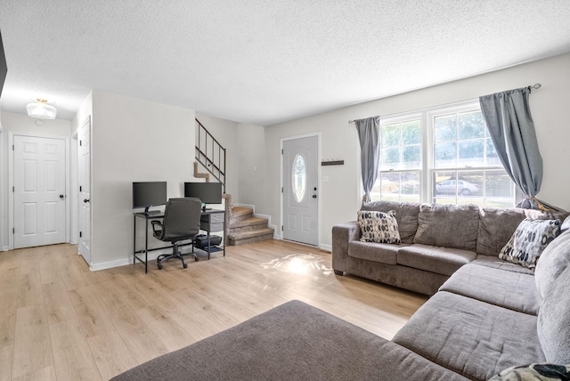 living room featuring a textured ceiling and light hardwood / wood-style flooring