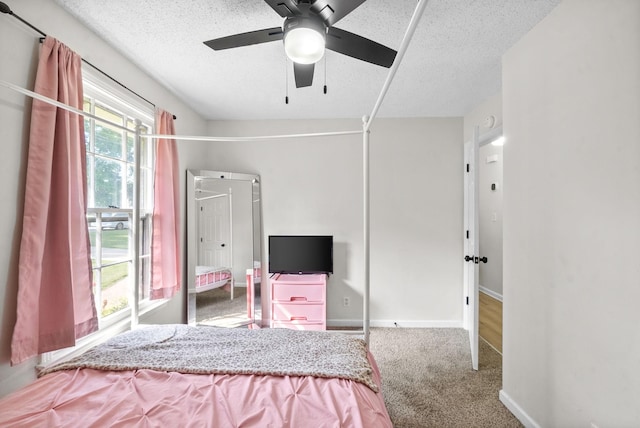 carpeted bedroom with a textured ceiling and ceiling fan