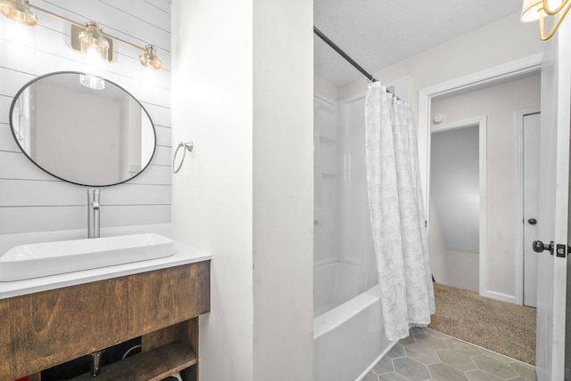 bathroom with tile patterned floors, a textured ceiling, vanity, wooden walls, and shower / bathtub combination with curtain