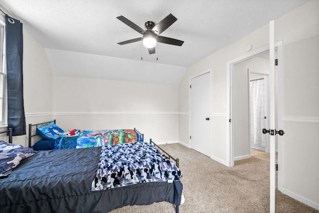 carpeted bedroom featuring lofted ceiling, a textured ceiling, and ceiling fan