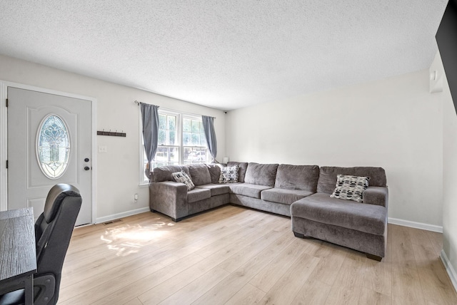 living room with a textured ceiling and light wood-type flooring