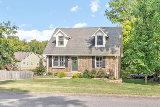 cape cod house featuring a front lawn