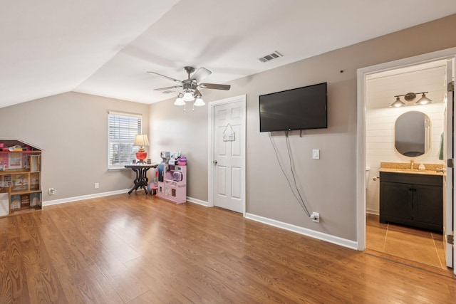 recreation room with hardwood / wood-style floors, vaulted ceiling, sink, and ceiling fan