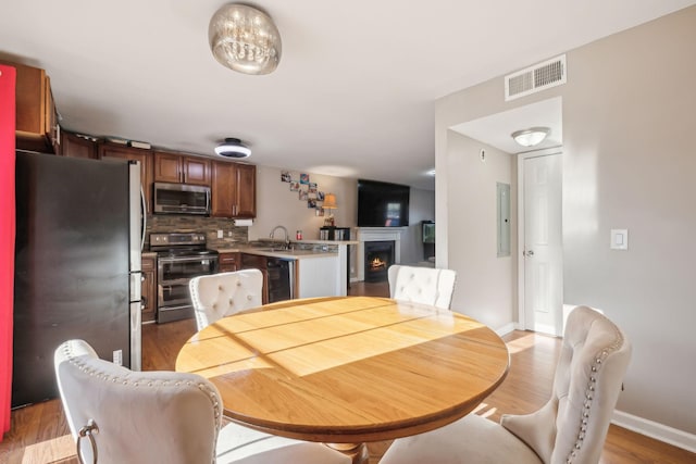 dining space with sink and light hardwood / wood-style floors