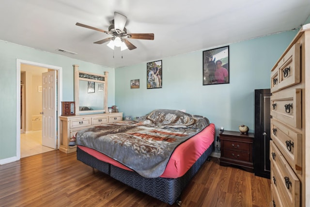 bedroom with ceiling fan, ensuite bathroom, and dark hardwood / wood-style flooring