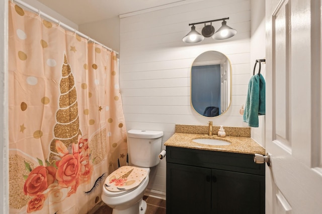 bathroom featuring vanity, wooden walls, toilet, and walk in shower