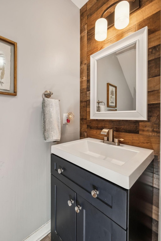 bathroom featuring vanity and wooden walls