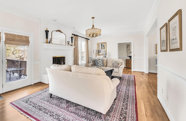 living room with ornamental molding, a brick fireplace, and light hardwood / wood-style flooring