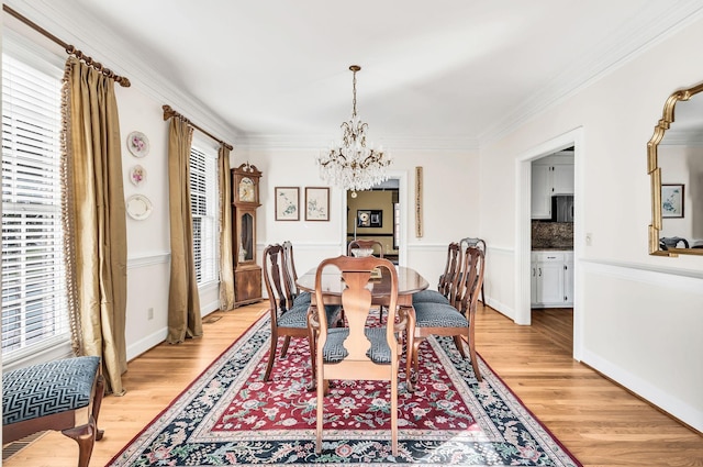 dining room featuring an inviting chandelier, ornamental molding, and light wood-type flooring