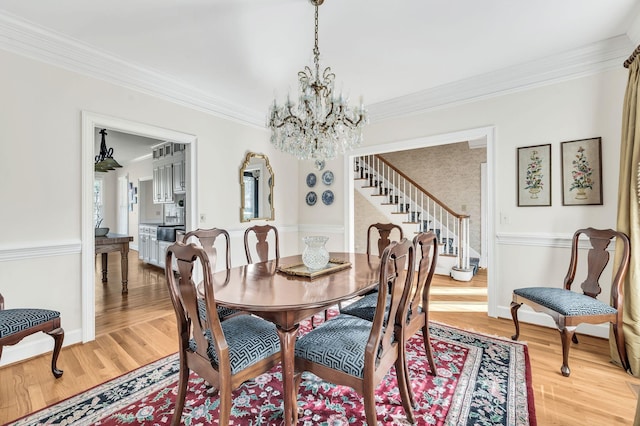 dining room featuring crown molding, wood-type flooring, and a chandelier