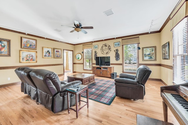 living room featuring crown molding, light hardwood / wood-style floors, and ceiling fan