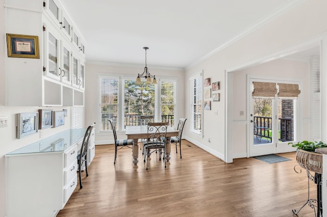 dining area with crown molding, a notable chandelier, and hardwood / wood-style flooring