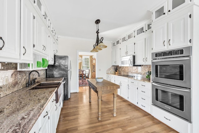 kitchen featuring light stone countertops, decorative light fixtures, stainless steel appliances, and white cabinets