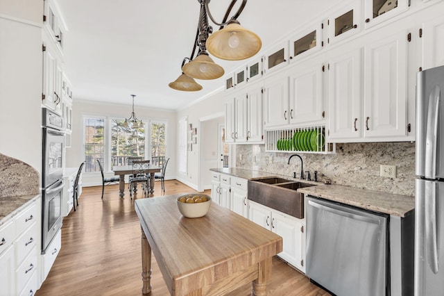 kitchen with light stone countertops, appliances with stainless steel finishes, and white cabinets