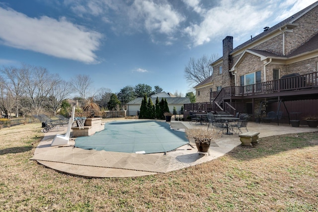 view of pool with a patio, a yard, and a deck