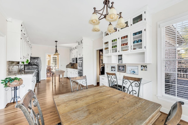 dining area with an inviting chandelier, hardwood / wood-style floors, and ornamental molding