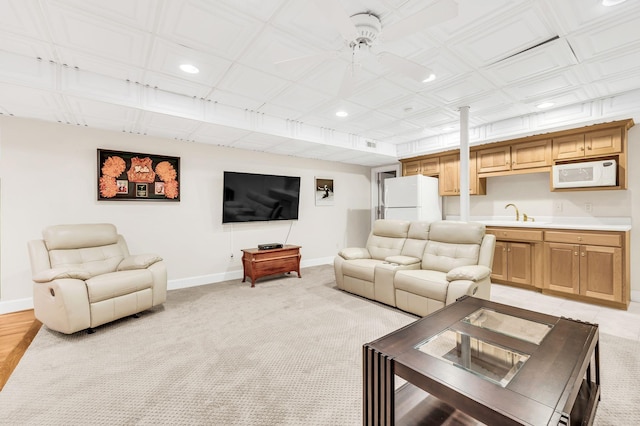 living room with sink, light carpet, and ceiling fan