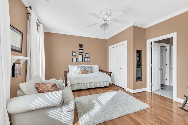 bedroom with hardwood / wood-style floors, crown molding, a closet, and ceiling fan