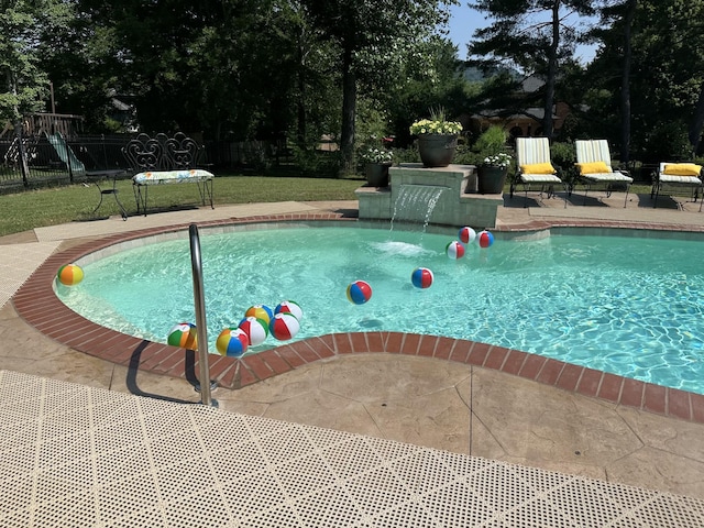 view of swimming pool featuring pool water feature and a patio