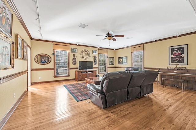 living room with crown molding, ceiling fan, rail lighting, and light hardwood / wood-style floors