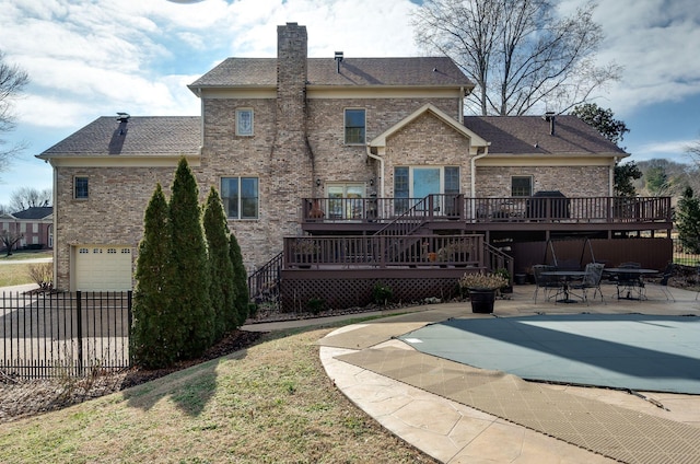 back of house with a garage, a swimming pool side deck, and a patio area