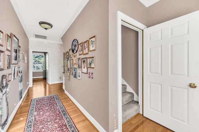 hall with hardwood / wood-style floors and crown molding