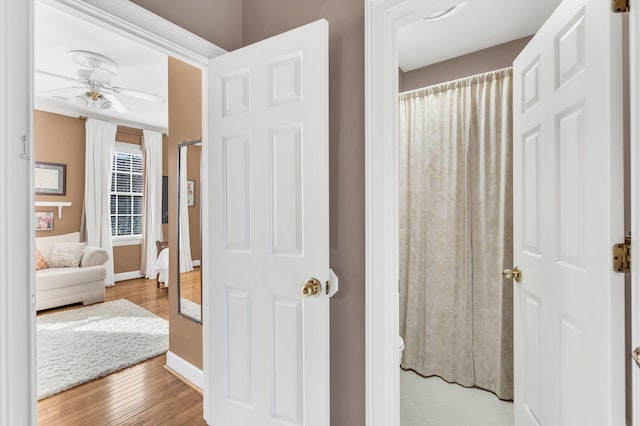 bathroom with ceiling fan and hardwood / wood-style floors