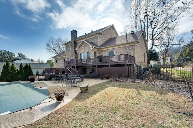 back of property with a swimming pool side deck, a yard, and a patio