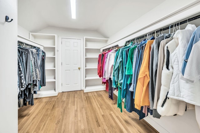 walk in closet featuring hardwood / wood-style floors and vaulted ceiling