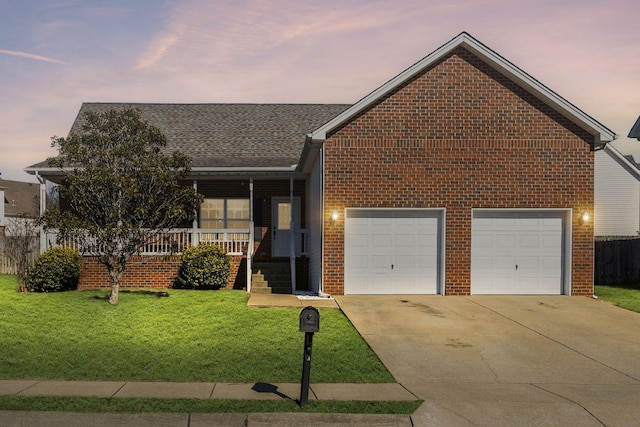 view of front of home featuring a garage, a lawn, and covered porch