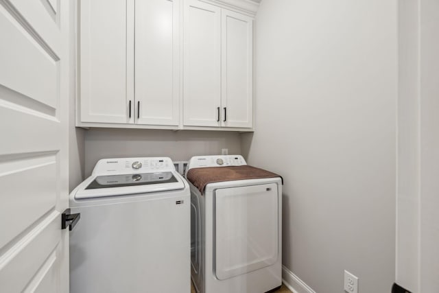 washroom featuring cabinets and washing machine and dryer