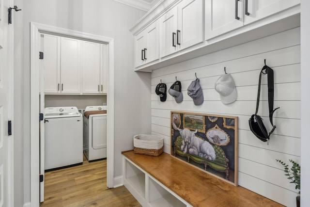 mudroom with washer and clothes dryer, ornamental molding, and light wood-type flooring