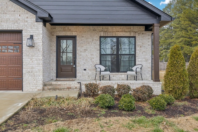 view of exterior entry featuring a garage and covered porch