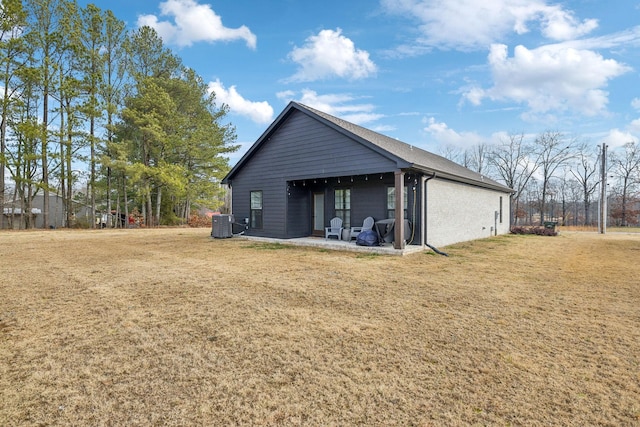 view of side of home with central AC, a lawn, and a patio