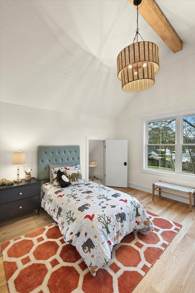 bedroom with lofted ceiling with beams and light hardwood / wood-style flooring