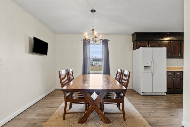 dining space with an inviting chandelier and light wood-type flooring