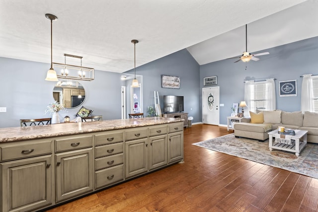 kitchen featuring lofted ceiling, dark wood-type flooring, ceiling fan, and decorative light fixtures