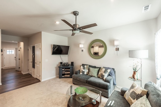 living room featuring ceiling fan and dark carpet