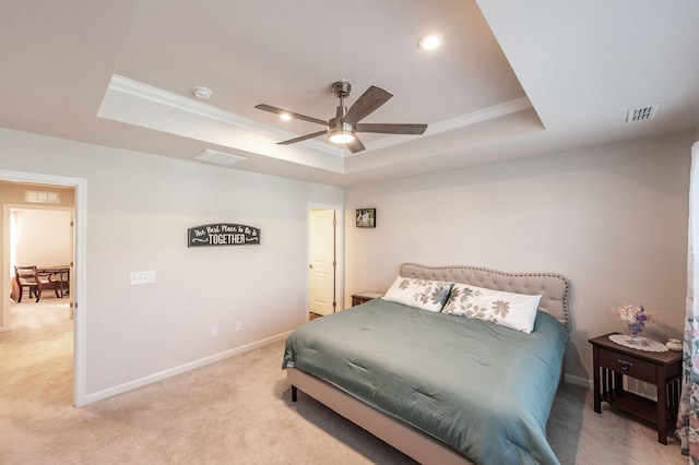 bedroom featuring ceiling fan, ornamental molding, a tray ceiling, and light colored carpet